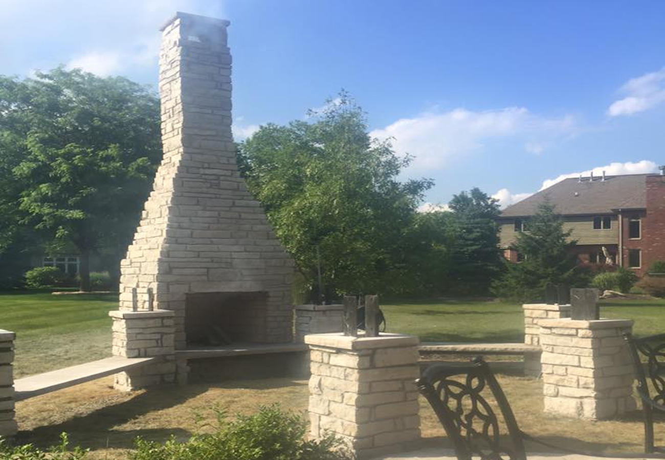 Outdoor stone fireplace fire pit built by Chicago contractor RK Masonry